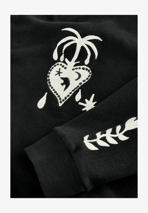 Hanorac negru cu modele albe brodate, inclusiv o inimă cu o palmieră, stele și un model de frunze pe mânecă.