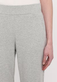 Lichtgrijze sweatpants van een zachte katoenmix, met een elastische tailleband en een klein logo aan de zijkant. Soepele textuur, casual pasvorm.
