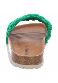 Sandalia con tira tejida verde y plantilla de corcho, suela marrón suave y entresuela blanca brillante. Las características incluyen una textura surcada y un logotipo.