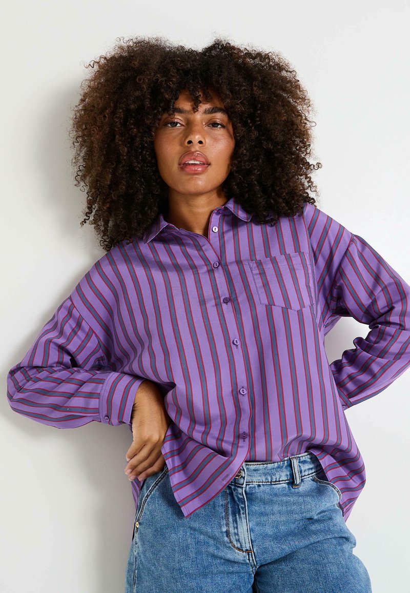 Femme en chemise à manches longues violette faisant du vélo sur la