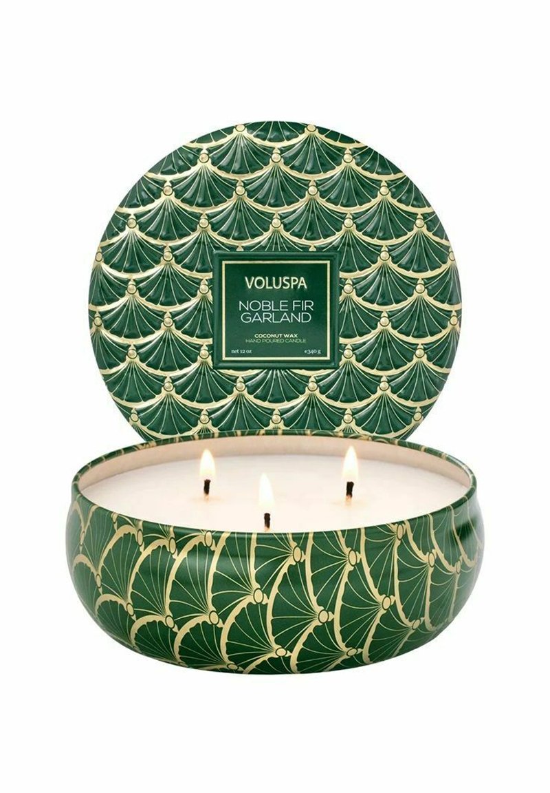Grön ljus med tre veker, inrymd i en dekorativ behållare med ett guldigt fläktmönster och en etikett som läser "Voluspa Noble Fir Garland."