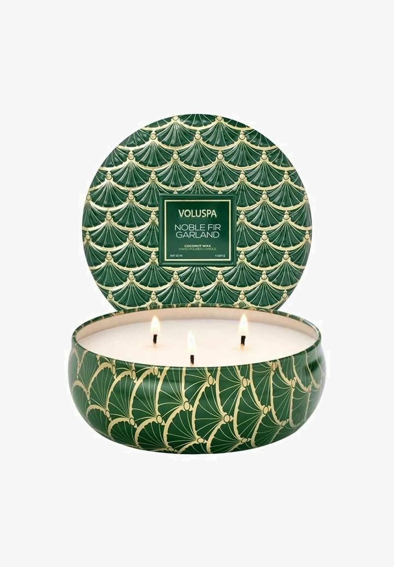 Grön ljus med tre veker, inrymd i en dekorativ behållare med ett guldigt fläktmönster och en etikett som läser "Voluspa Noble Fir Garland."