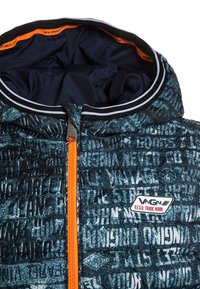 Vadderad jacka med ett blått och svart texturmönster, orange dragkedja och en kontrasterande innerfoder; logotyp-märke på framsidan.