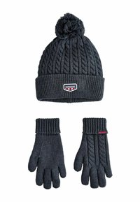 Dunkelgraue gestrickte Mütze mit einem Pompon und Kabelmuster. Passende Handschuhe mit einem gerippten Bündchen und Kabeldesign auf einer Seite. Markenlogo sichtbar.