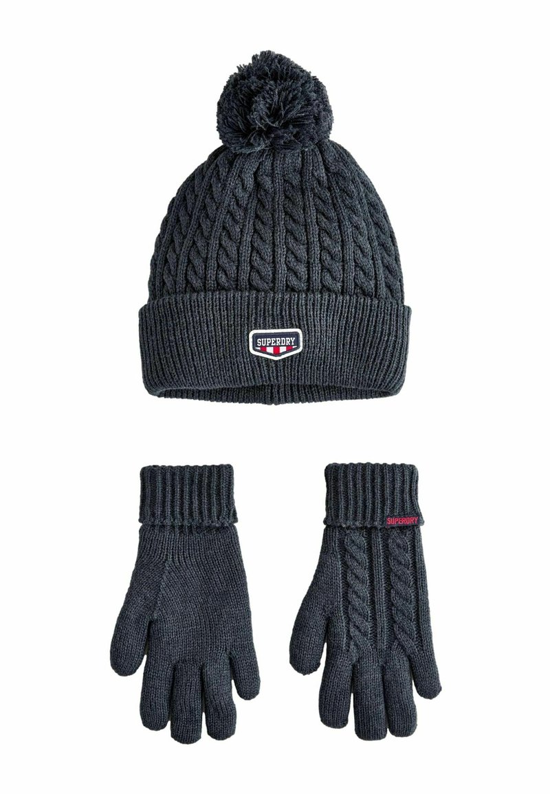 Dunkelgraue gestrickte Mütze mit einem Pompon und Kabelmuster. Passende Handschuhe mit einem gerippten Bündchen und Kabeldesign auf einer Seite. Markenlogo sichtbar.