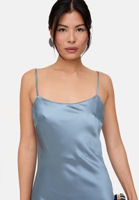 Kleid im Camistil aus Satin, hellblaue Farbe, schmale Spaghettiträger, gerader Ausschnitt, figurbetonte Silhouette, glatte Textur.