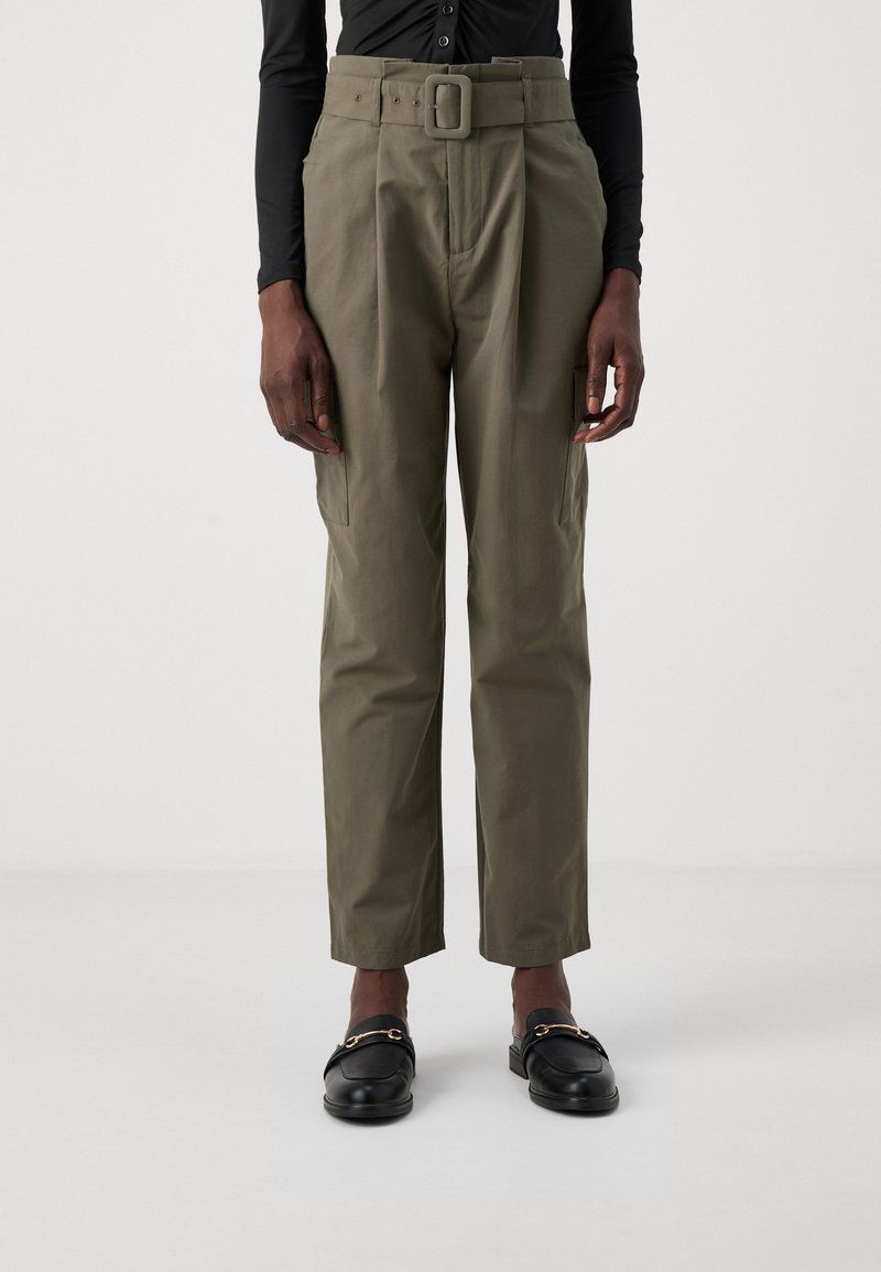 Olive green cargo trousers with a wide belt, pleated front, and side pockets. Worn with black loafers featuring gold hardware accents.