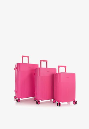 Set di tre valigie rigide di colore rosa brillante con maniglie telescopiche e quattro ruote doppie girevoli, disposte in ordine decrescente di dimensione.