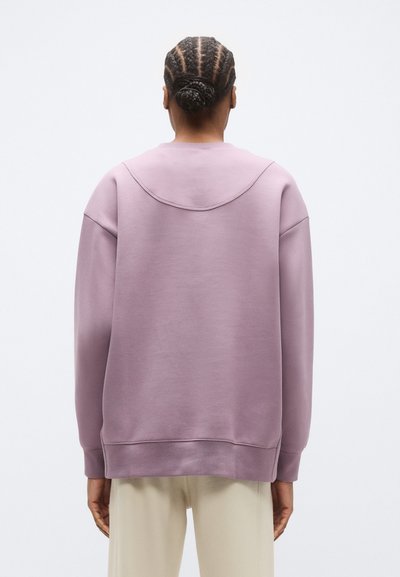 Μωβ φούτερ με άνετη εφαρμογή, ριμπ μανσέτες και καμπυλωτό τελείωμα. Ομαλή υφή υφάσματος με στρογγυλή λαιμόκοψη και διακριτικές ραφές.