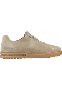 Beige semsket sneaker med lav profil, rund tå og tan gummisåle med korkdetalj langs siden. Snørebånd og minimal merking.