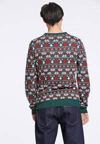 Sweter dzianinowy w zielonej podstawie z geometrycznym wzorem w kolorach czerwonym, białym i niebieskim, z długimi rękawami oraz ściągaczami u dołu i na mankietach.