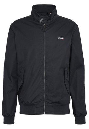 Chaqueta negra con cremallera frontal, cuello alto, puños y cintura elásticos, bolsillos laterales y un pequeño logo en el pecho izquierdo. Textura de tela suave.
