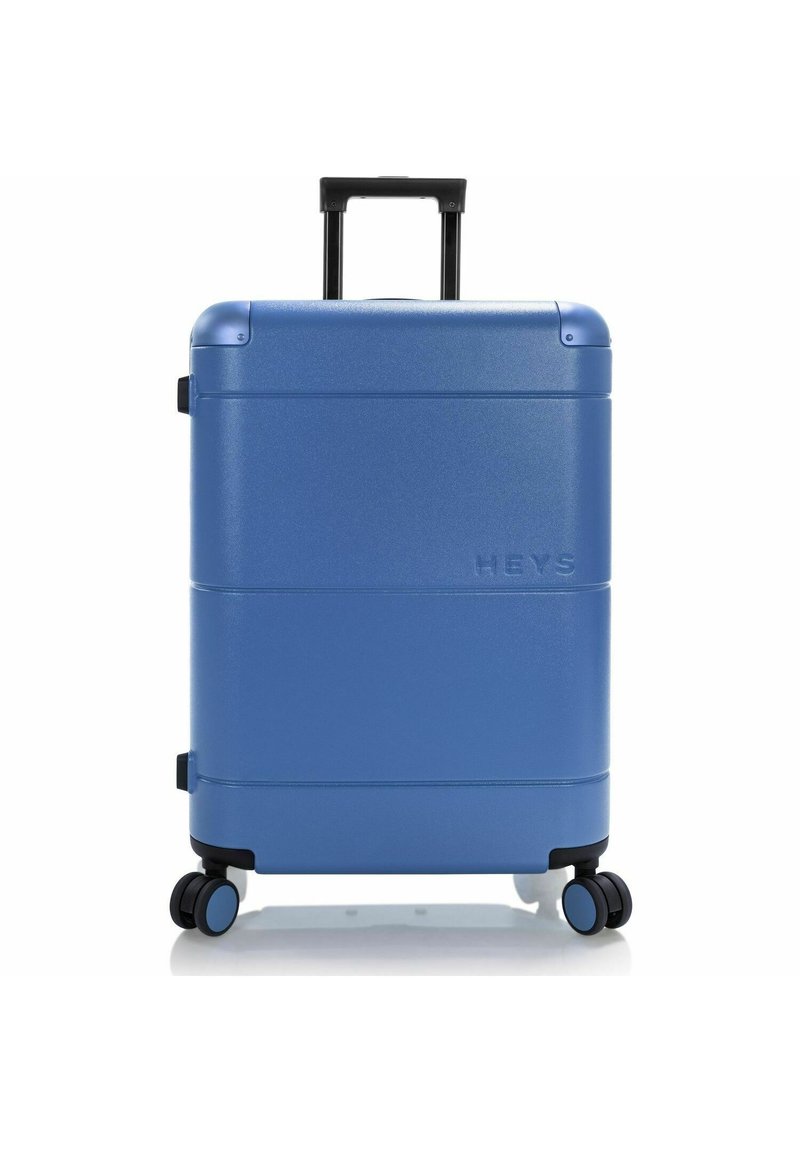 Valise rigide bleue avec une finition texturée, deux roues lisses, une poignée rétractable et un logo sur le panneau avant.