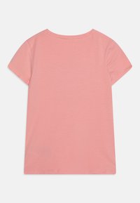 T-shirt à manches courtes en coton léger et doux, de couleur rose clair. Design classique à col rond avec une texture lisse et sans motifs ni détails visibles.