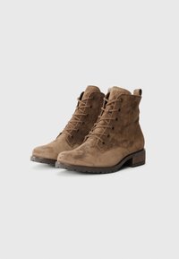 Stivali ankle in suede marrone con design lacci, punta rotonda e un piccolo tacco in legno. La superficie ha una consistenza morbida e dettagli minimi.