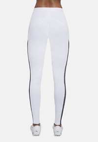 Białe legginsy z elastycznej tkaniny, z czarnymi bocznymi paskami, dopasowanym krojem i wysokim stanem. Teksturalne wykończenie wzdłuż szwów.