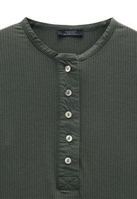 Ciemnozielony, prążkowany top henley z zaokrąglonym dekoltem i sześcioma guzikami w jasnym kolorze. Teksturowany detal przy kołnierzyku.