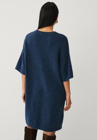 Overdimensioneret, løstsiddende, marineblå sweaterkjole med korte ærmer, lavet af blødt, tekstureret strikmateriale, med rund halsudskæring og ribbet kant.
