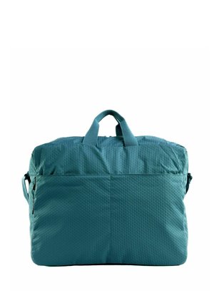 Sac fourre-tout en tissu bleu texturé avec des anses courtes et un compartiment principal zippé sur fond blanc.