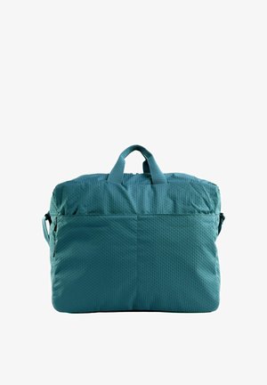 Sac fourre-tout en tissu bleu texturé avec des anses courtes et un compartiment principal zippé sur fond blanc.