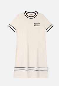 Robe en tricot crème à manches courtes avec des bordures noires au col, aux manches, à l'ourlet et une petite poche sur la poitrine avec un détail en chaîne dorée.