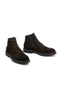 Brown suede ankle boots with a rounded toe, lacing system, and side zipper. Features a flat rubber sole and stitched detailing.