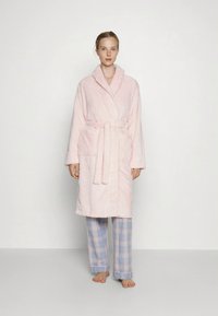 Rožinės spalvos tekstūruotas chalatas su šaliko tipo apykakle, diržu ties liemeniu ir dviem priekinėmis kišenėmis. Derinamas su šviesiai mėlynomis languotomis pižamos kelnėmis.