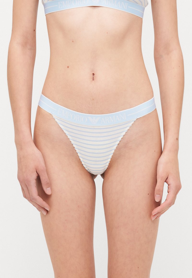 Zila un balta svītraina tanga apakšveļa ar maigu ribota auduma tekstūru un gludu jostas vietu, kas rotāta ar "Emporio Armani" logo.