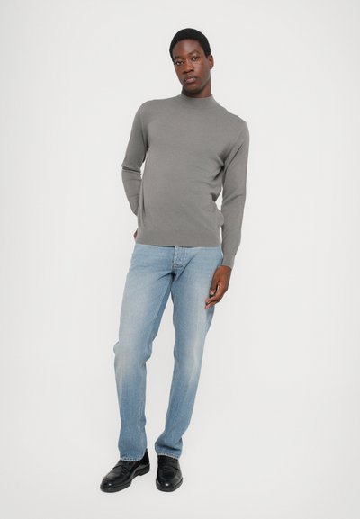 Gray long-sleeve turtleneck sweater paired with light blue straight-leg jeans and black leather shoes. Simple design, no visible patterns.