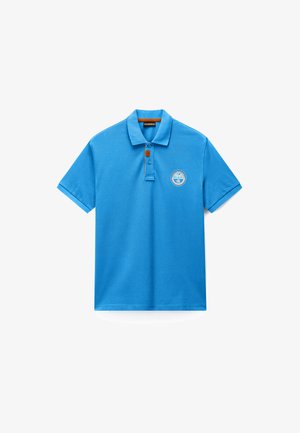 Niebieska koszulka polo z krótkim rękawem, kołnierzykiem, dwukolorową listwą guzikową i okrągłą naszywką z logo na lewej piersi.