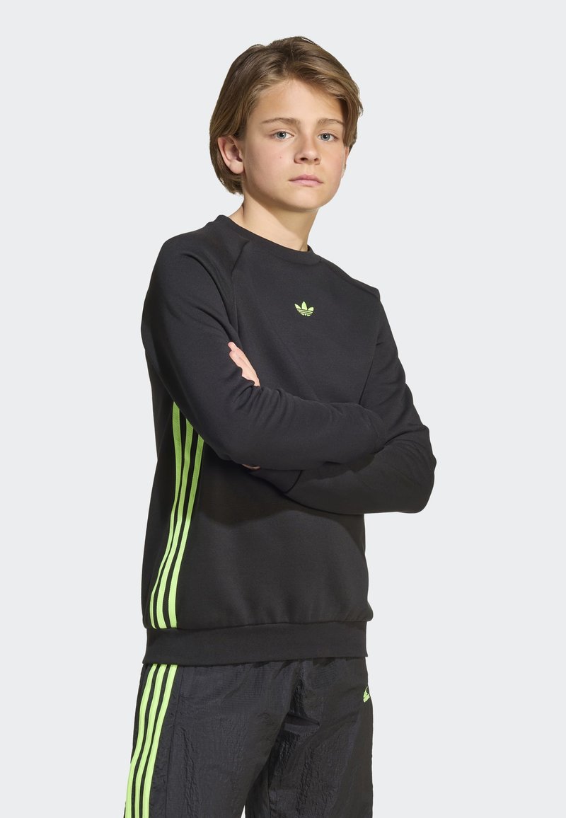 Black sweatshirt with green three-stripe accents on sleeves and small logo. The fabric appears smooth, with a crew neck design.