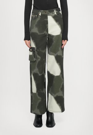 Cargo bukser i et grønt og cremefarvet camouflage mønster, lavet af et robust stof, med sidelommer og en løs pasform.