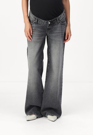 Gray wide-leg jeans with a faded finish, featuring a high waist, front pockets, and subtle stitching details. Worn with pointed white heels.