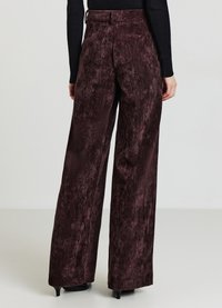 Bordeauxrote Hosen mit weitem Bein aus einem strukturierten, samtigen Stoff. Hohe Taille mit Gürtelschlaufen, ausgestattet mit einer glatten Oberfläche und minimalen Nahtdetails.