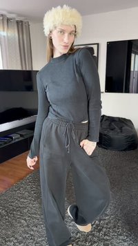 Black ribbed long-sleeve top paired with loose black pants, featuring an elastic waist. Accessorized with a fluffy white headband.