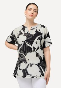 Bluse med sort-hvid blomsterprint, korte ærmer, V-hals design, letvægtsstof, afslappet pasform, med buet kant og sideslids.