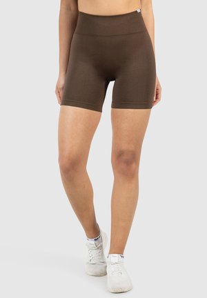 Bruine high-waisted shorts van een gladde, stretchy stof. Ze hebben een getailleerd ontwerp en een naadloze afwerking voor comfort en flexibiliteit.