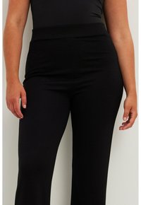 Melni, augsto jostasvietu bikses ar gludu, elastīgu audumu. Dizains ietver pieguļu formu un platu jostasvietu komfortam.