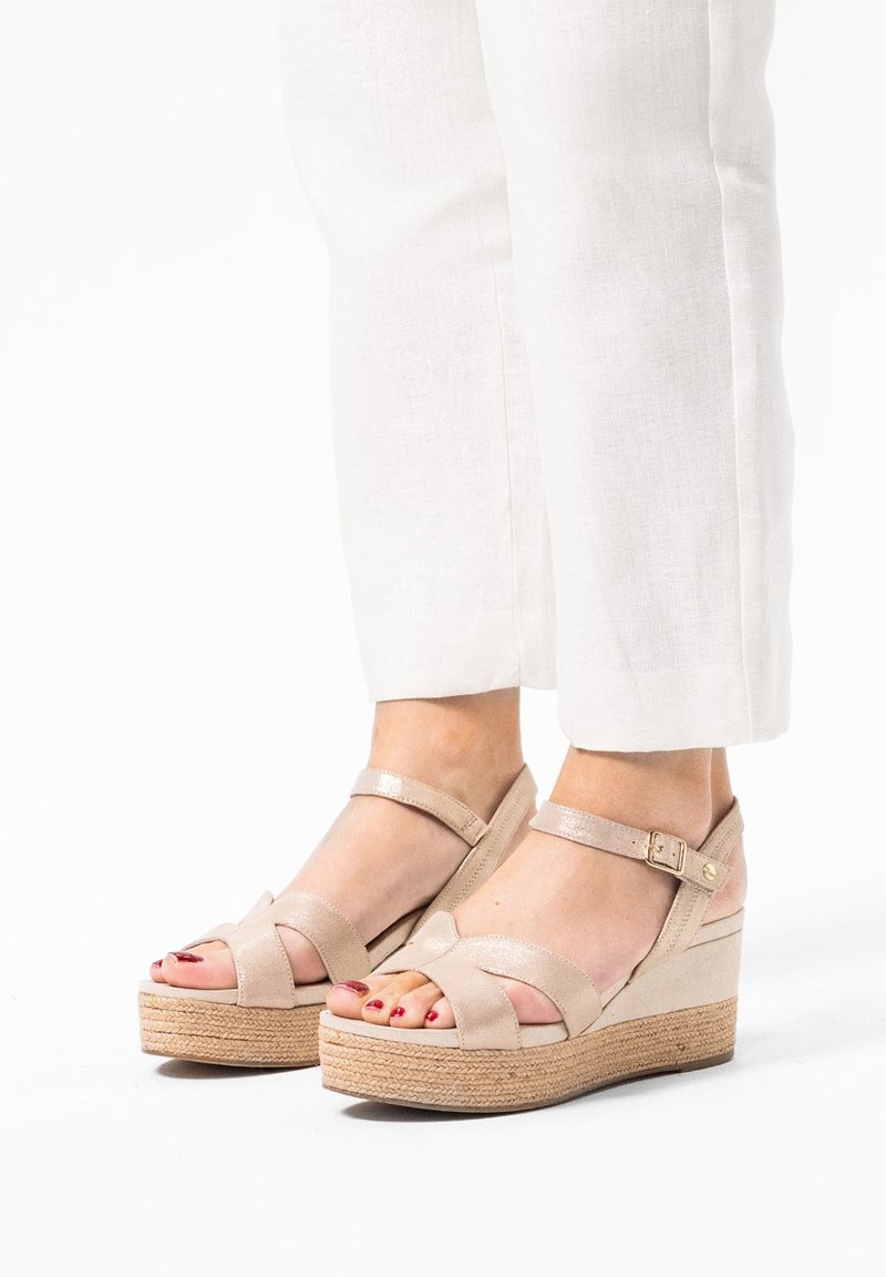 Beige wedge sandalen met gespsluiting en enkelbandje. Lichtjes gestructureerd oppervlak en jute-wikkel middenzool. Blootgestelde tenen met gepolijste nagels.