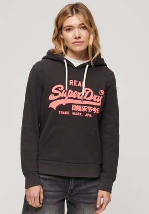 Felpa nera con cappuccio e tasca frontale, caratterizzata da un grande design logo rosa. Tessuto misto cotone, cappuccio con cordino, polsini e orlo a costine.