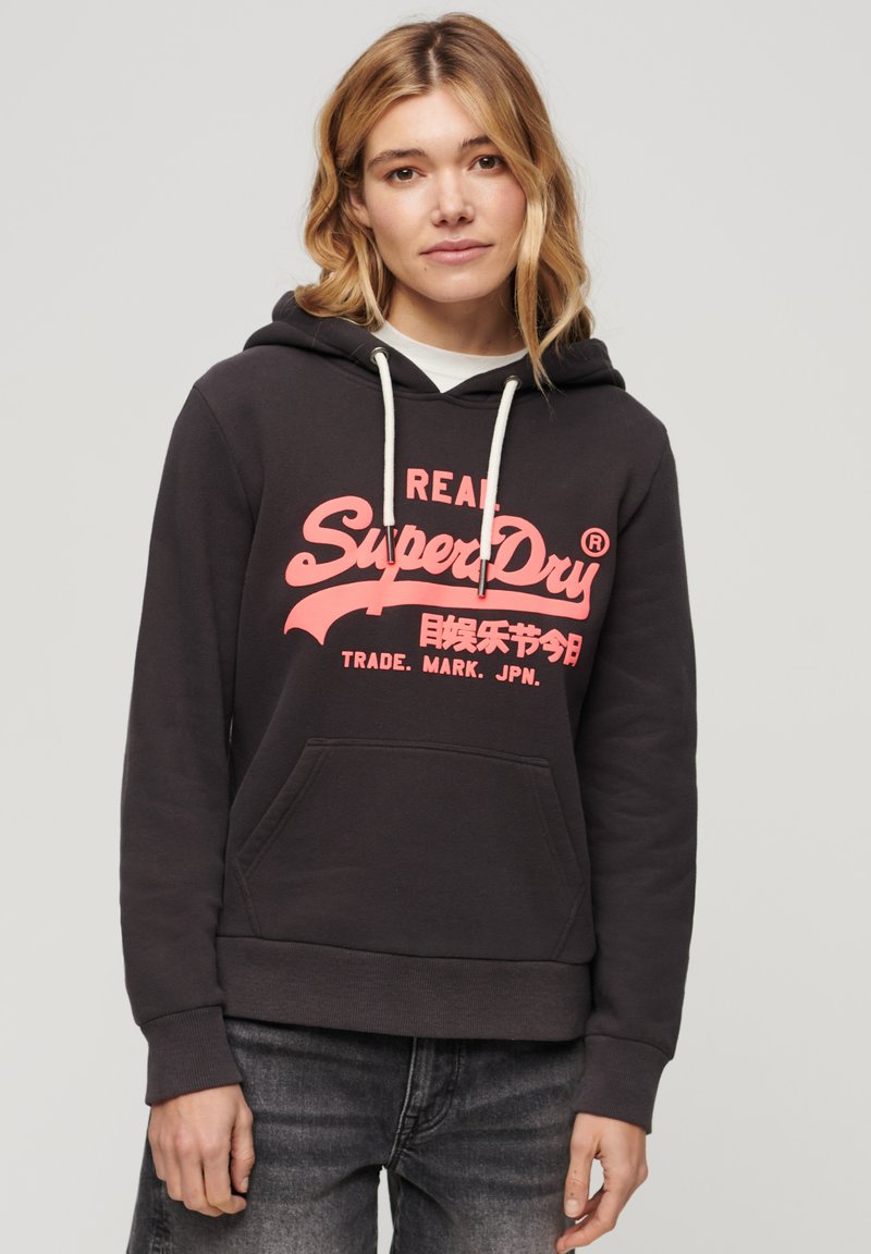 Felpa nera con cappuccio e tasca frontale, caratterizzata da un grande design logo rosa. Tessuto misto cotone, cappuccio con cordino, polsini e orlo a costine.