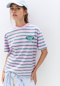 Gestreept T-shirt met roze en groene horizontale lijnen, voorzien van een grafisch "SNACK TIME SALTY&SWEET" logo, gemaakt van zachte katoen.