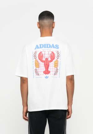 Hvit bomull t-skjorte med et fargerikt hummergrafikk, blader, sitroner og et rutete bakgrunn på baksiden. Adidas-logo øverst.