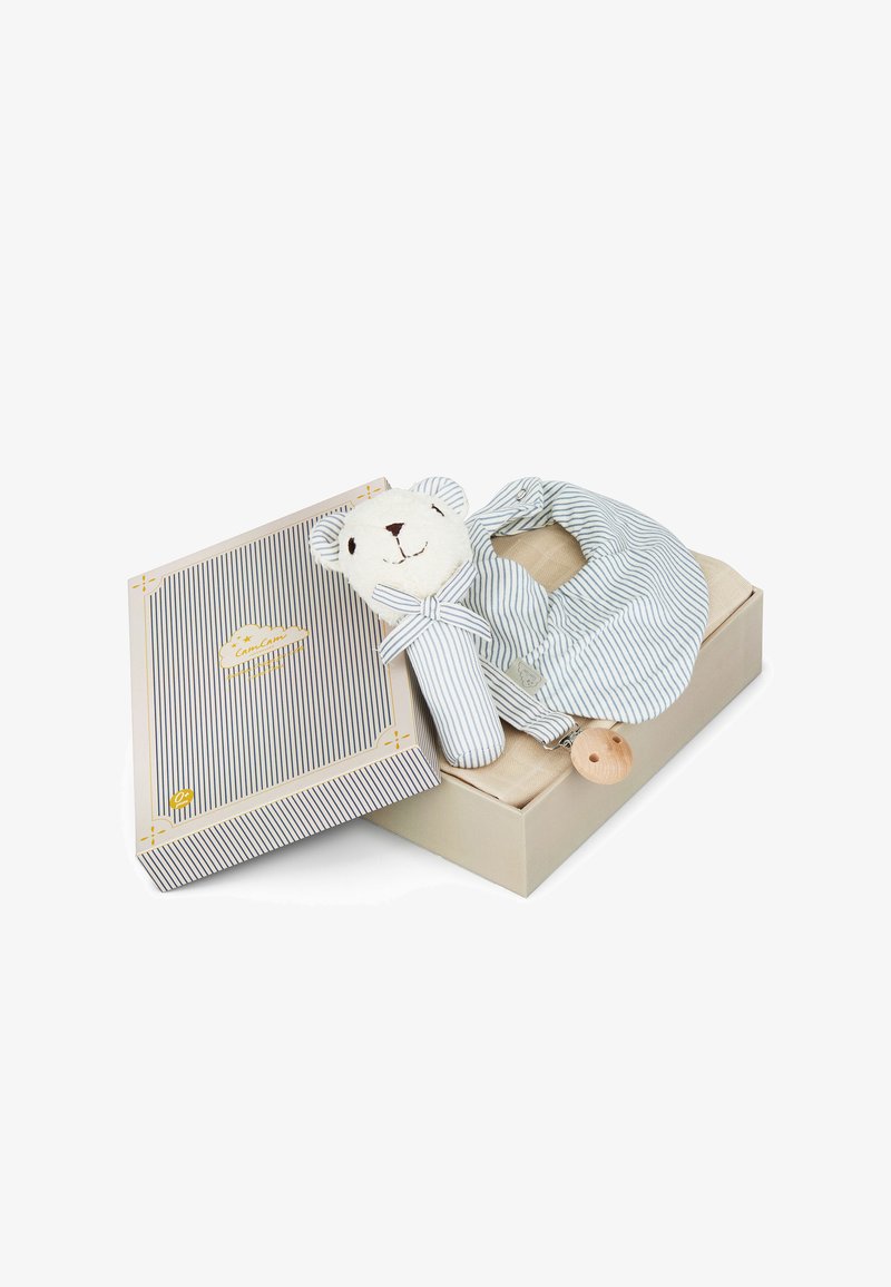 Myk hvit bamse i plysh med kropp i stripet stoff og sløyfe, liggende på en beige eske med matchende stripete lokk, lyse tre-tenner festet.