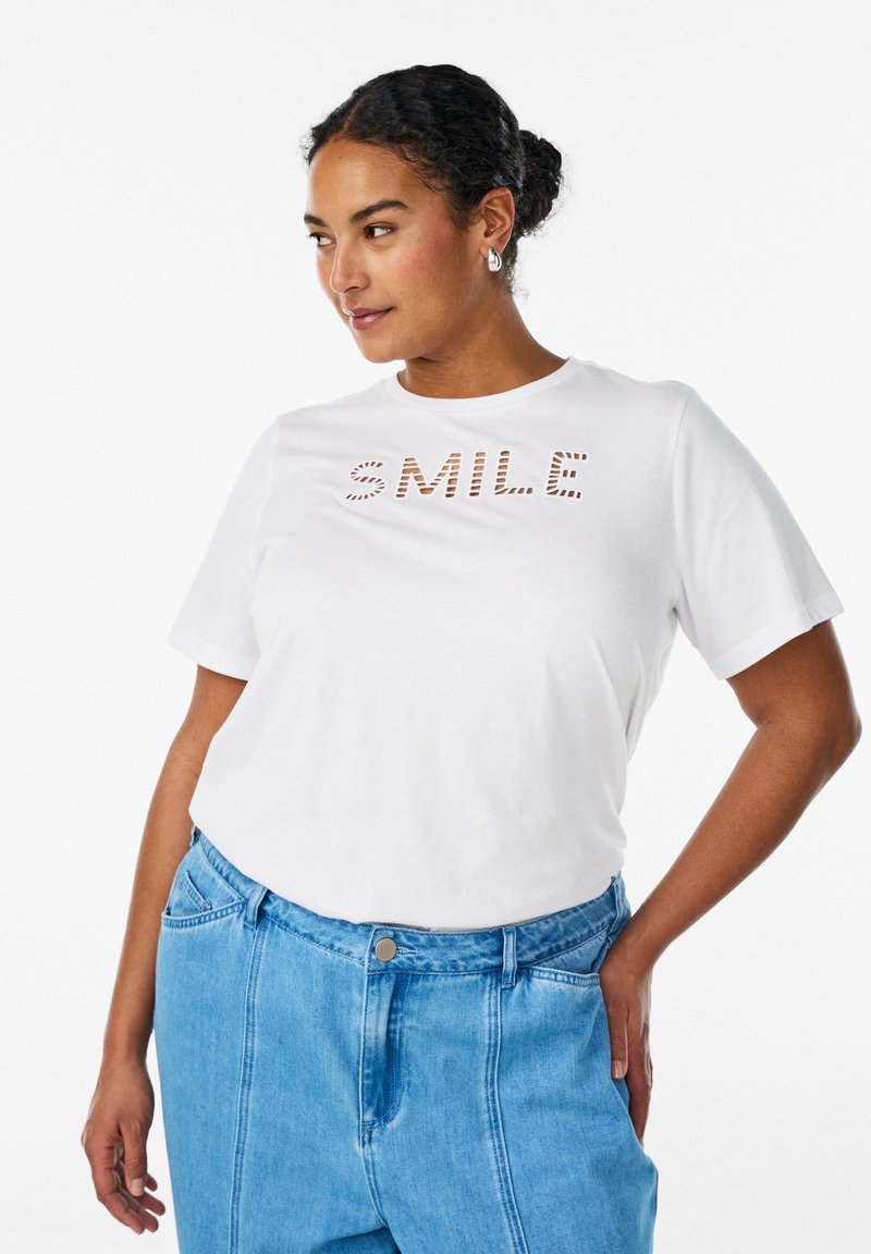 Λευκό βαμβακερό t-shirt με σχέδιο «SMILE» σε αντίθετο καφέ ριγέ κείμενο. Κοντά μανίκια, στρογγυλή λαιμόκοψη, άνετη εφαρμογή.