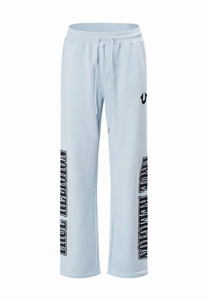 Lichtblauwe joggingbroek met trekkoord in de taille, wijde pijpen en "True Religion" verticaal in het zwart gedrukt op beide pijpen.