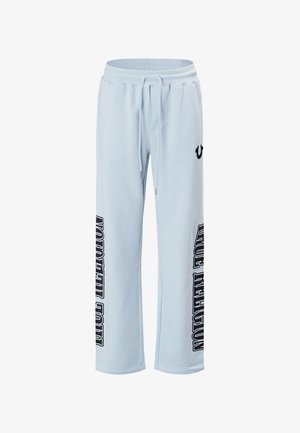 Hellblaue Jogginghose mit Kordelzugbund, weitem Bein und dem Schriftzug "True Religion" in Schwarz vertikal auf beiden Hosenbeinen gedruckt.