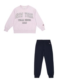 Sudadera lila con "NEW YORK TEAM SINCE 1919" en impresión negrita, combinada con joggers azul marino, que tienen una cinturilla y puños elásticos.