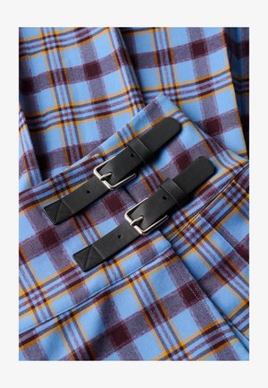 Rutete stof i blå, bordeaux og gul. To sorte læderremme med sølvspænder er fremtrædende.