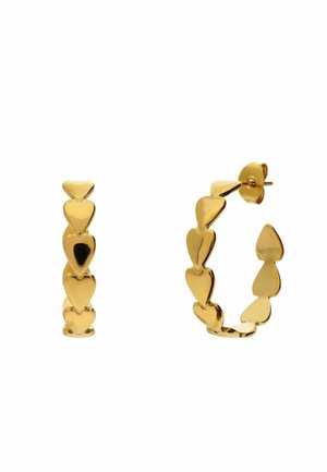 Gouden creolen gemaakt van verbonden hartvormen met pen- en vlindersluiting op een witte achtergrond.
